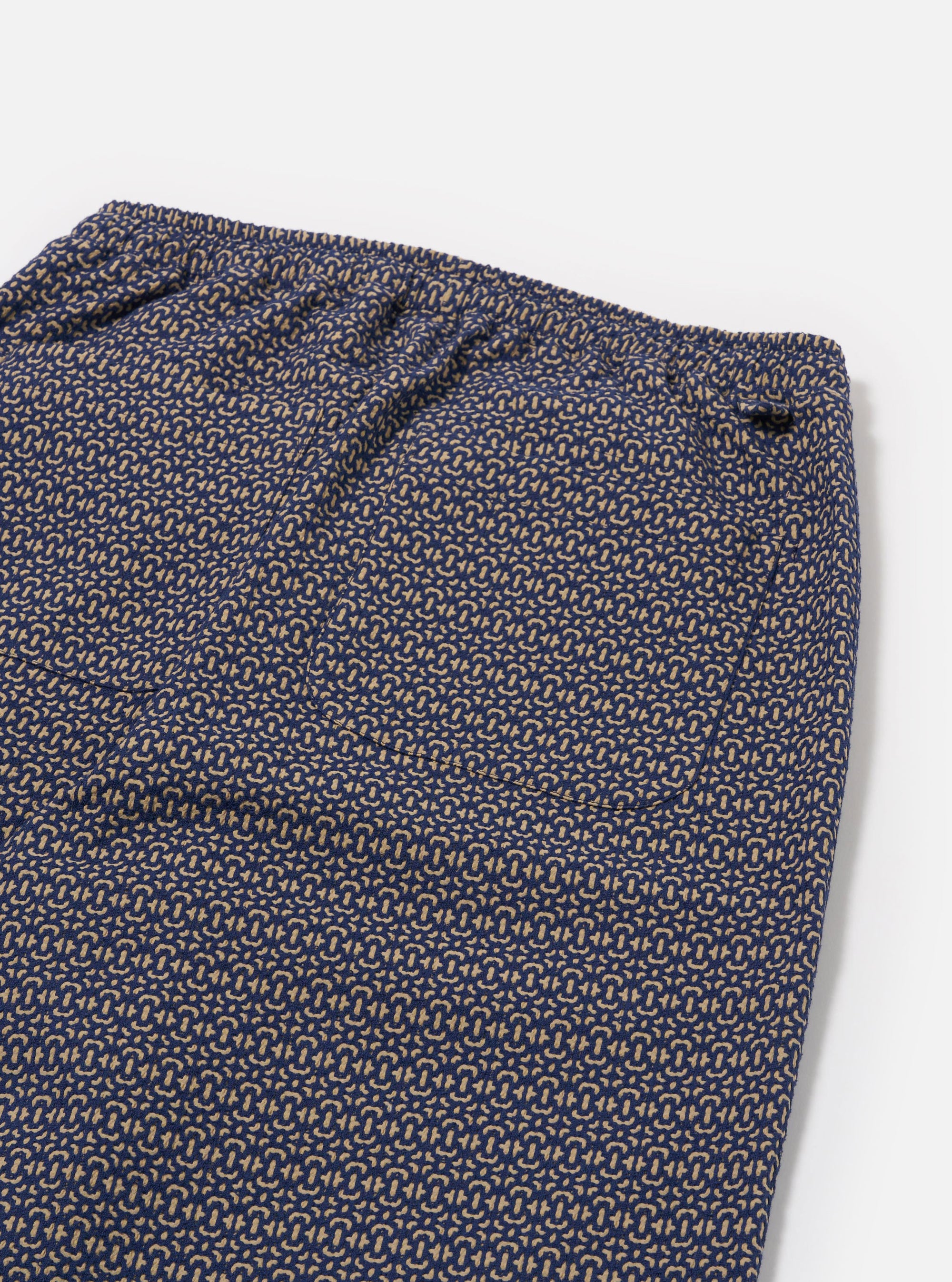 The Navy Konos Cotton Judo Pant is shown as a flat lay from the back against a plain white background. The image highlights the two rear patch pockets and the elasticated waistband of the trousers. The navy blue fabric features an all-over intricate pattern.