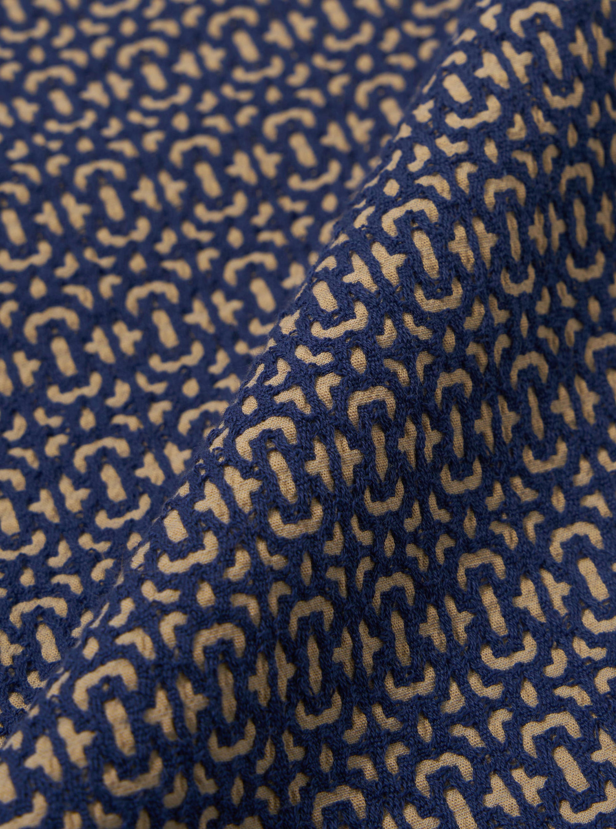 A close-up fabric swatch of the Navy Konos Cotton Judo Pant highlights the textured weave and deep navy blue color of the cotton material. The fabric fills the frame, providing a detailed view of the garment's construction and pattern.