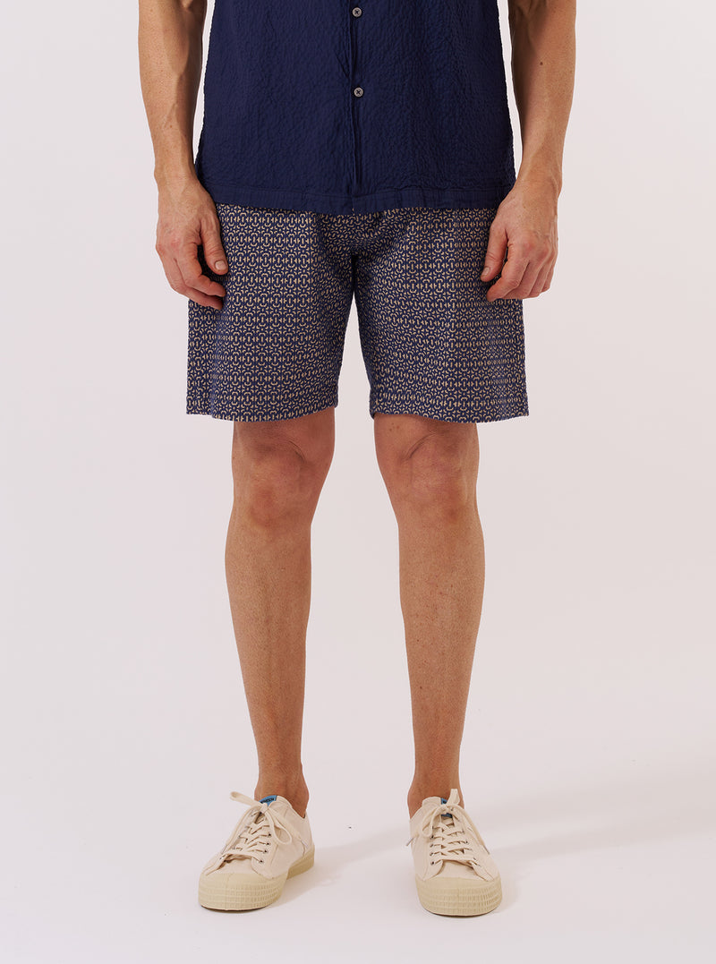 A model wears the Navy Konos Cotton Simple Short, shown from the waist down against a plain white background. The shorts feature a relaxed fit, an elasticated waistband, and side pockets. The navy fabric has a visible textured woven pattern throughout.