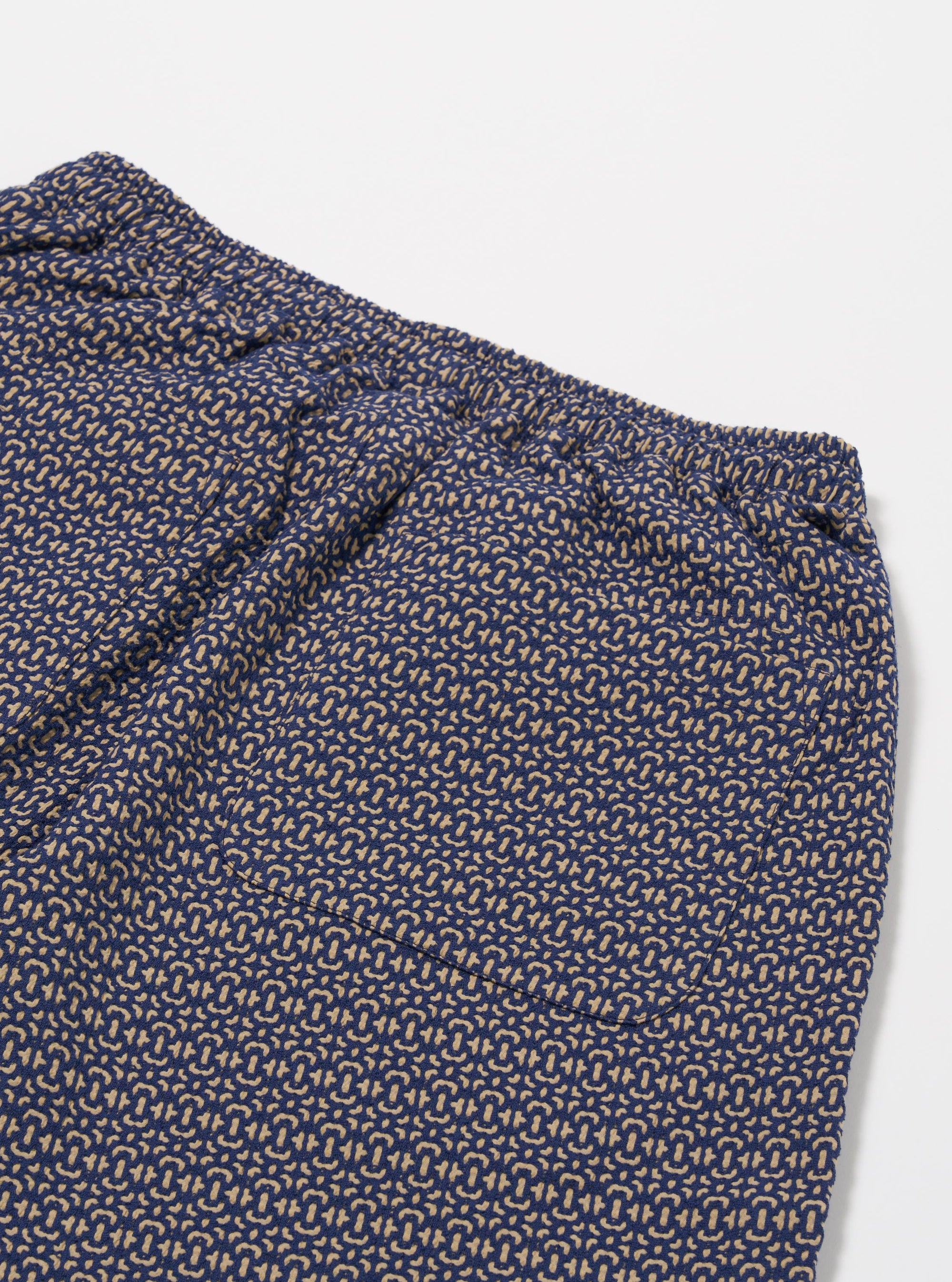 The Navy Konos Cotton Simple Short is shown from the back as a flat lay against a plain white background. The shorts feature an elasticated waistband and a single rear patch pocket. The navy cotton fabric highlights a patterned texture.