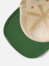 The Ecru/Sand Canvas Baseball Hat is shown as a flat lay from the rear against a plain white background. The hat features a six-panel construction made from ecru cotton canvas and includes a tan leather adjustable strap with a silver-tone metal clasp at the back. Tonal embroidered eyelets are visible on the crown panels.