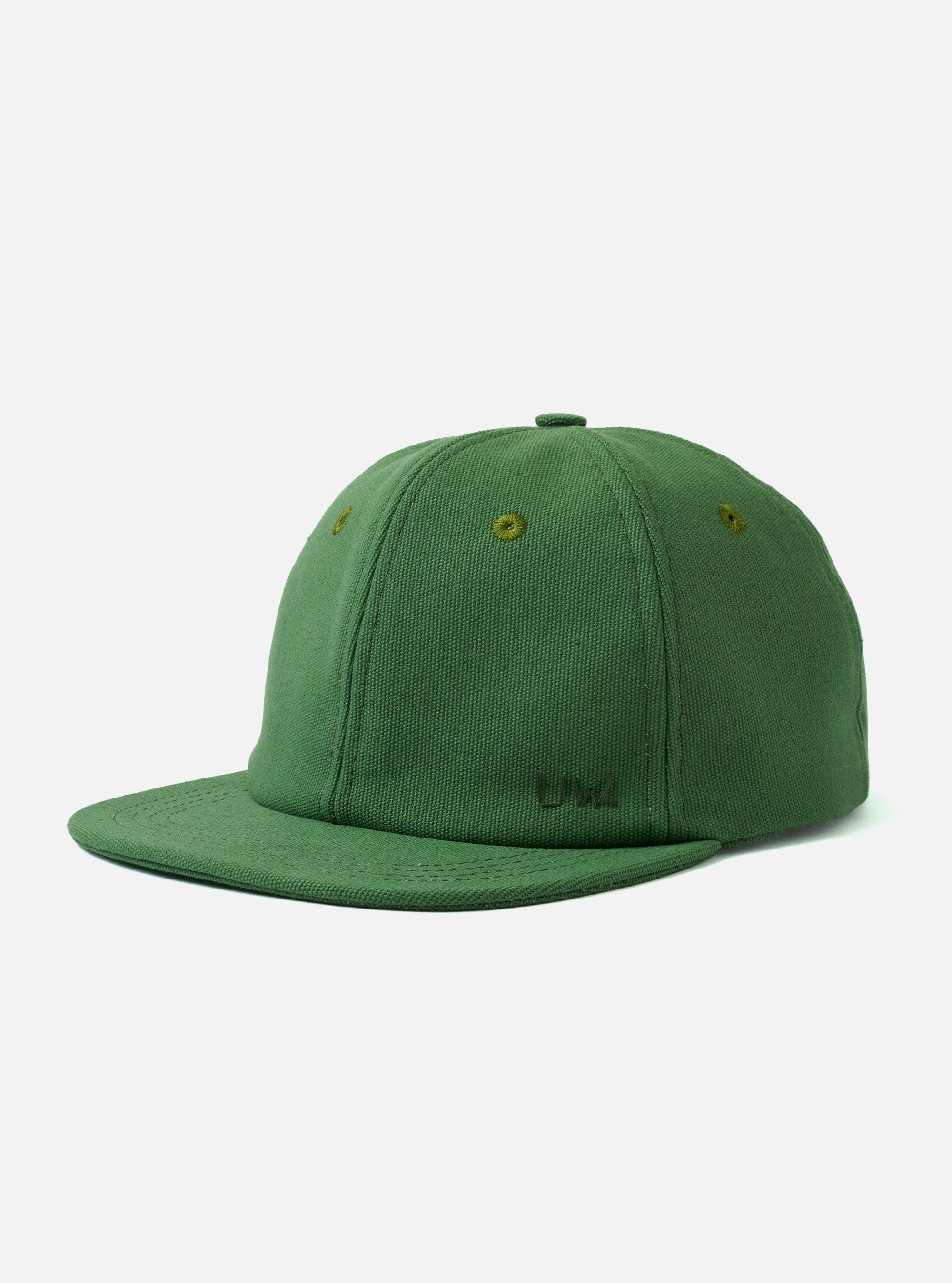 The Green Canvas Baseball Hat is shown from a front-side angle as a flat lay against a plain white background. The hat features a classic six-panel construction, a curved brim, and tonal eyelets for ventilation. The material is a durable green cotton canvas with a matte finish.