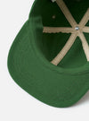 The Green Canvas Baseball Hat is displayed from a rear angle as a flat lay against a plain white background. The image highlights the adjustable fabric strap with a metal buckle and the tonal embroidered eyelets on the crown panels. The green canvas material shows a sturdy texture and clean stitching.