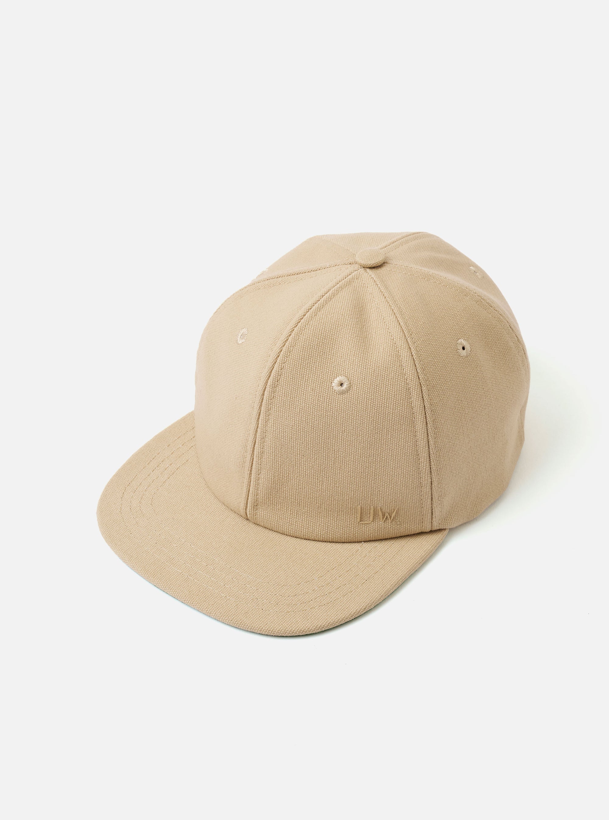 The Sand Canvas Baseball Hat is shown as a flat lay against a plain white background. The image displays the back of the hat, highlighting the adjustable strap with a metal buckle and the curved brim. The sand-colored cotton canvas fabric features tonal stitching and ventilation eyelets.