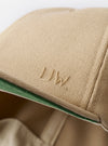 The Sand Canvas Baseball Hat is shown from a rear three-quarter angle as a flat lay against a plain white background. The image highlights the adjustable fabric strap with a metal buckle and the structured six-panel construction of the crown. The sand-colored cotton canvas fabric has a smooth, durable texture.