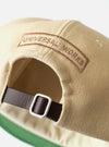 The Sand Canvas Baseball Hat is shown as a flat lay against a plain white background. The image displays the six-panel cap in a light sand color, featuring a curved brim and tonal embroidered eyelets. The cotton canvas fabric has a visible, durable texture.