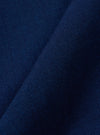 A close-up swatch image of the Indigo Kimstop Pleated Track Pant fabric highlights the deep indigo blue color and the fine grid-like texture of the cotton ripstop material.