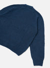 Navy alpaca knit cardigan laid flat on a light grey surface, shot from above at an angle. The back body and one full sleeve are visible, showing a soft, slightly fluffy knit texture. Ribbed trim runs along the hem and cuff. The fabric is a deep navy blue with a fine, dense knit construction.
