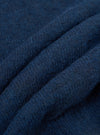 Close-up detail of the navy alpaca knit fabric of the David Cardigan, showing soft, slightly hairy fibres and a textured knit structure. The fabric is gathered into deep folds, highlighting its weight and warmth. Shot against a plain white studio background.