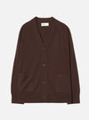 Espresso brown merino knit cardigan laid flat on a light grey backdrop. V-neck with a ribbed placket, four dark horn-effect buttons, two patch pockets at the hip, raglan sleeves, ribbed cuffs and hem. Universal Works woven label visible at the inner neckline.