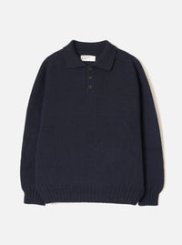 Navy Shetland knit polo sweater laid flat on a light grey seamless backdrop. Features a spread collar, three-button placket with dark buttons, chunky textured knit body, long sleeves, and a wide ribbed hem and cuffs. A Universal Works woven label is visible at the collar.