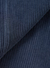 Close-up of dark navy corduroy fabric, showing wide-wale cord texture in detail. The fabric is folded to reveal the raised ribs and soft pile. A seam is visible on the left edge. The shot fills the entire frame with no background visible.