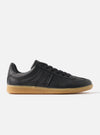 Side view of the Novesta for Universal Works Black Leather German Army Trainer on a white background. The shoe has a black leather upper and a gum-colored sole.
