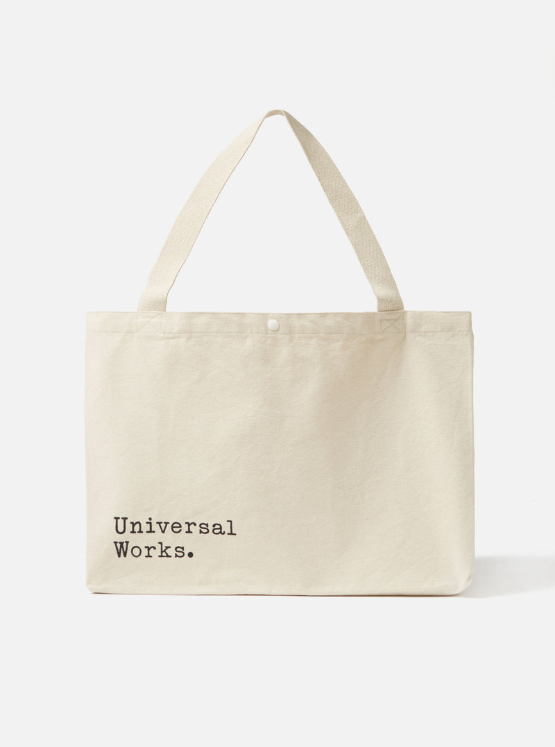 Studio shot of an Ecru Cotton Canvas Tote Bag against a white background. The bag has black text and ecru straps.