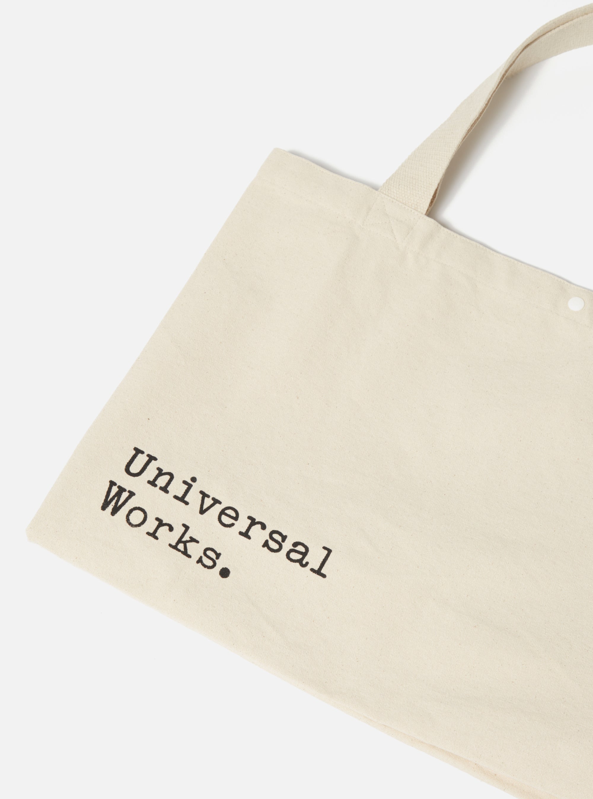 Close-up of an Ecru Cotton Canvas Tote Bag on a white background. The bag has black lettering and canvas handles.