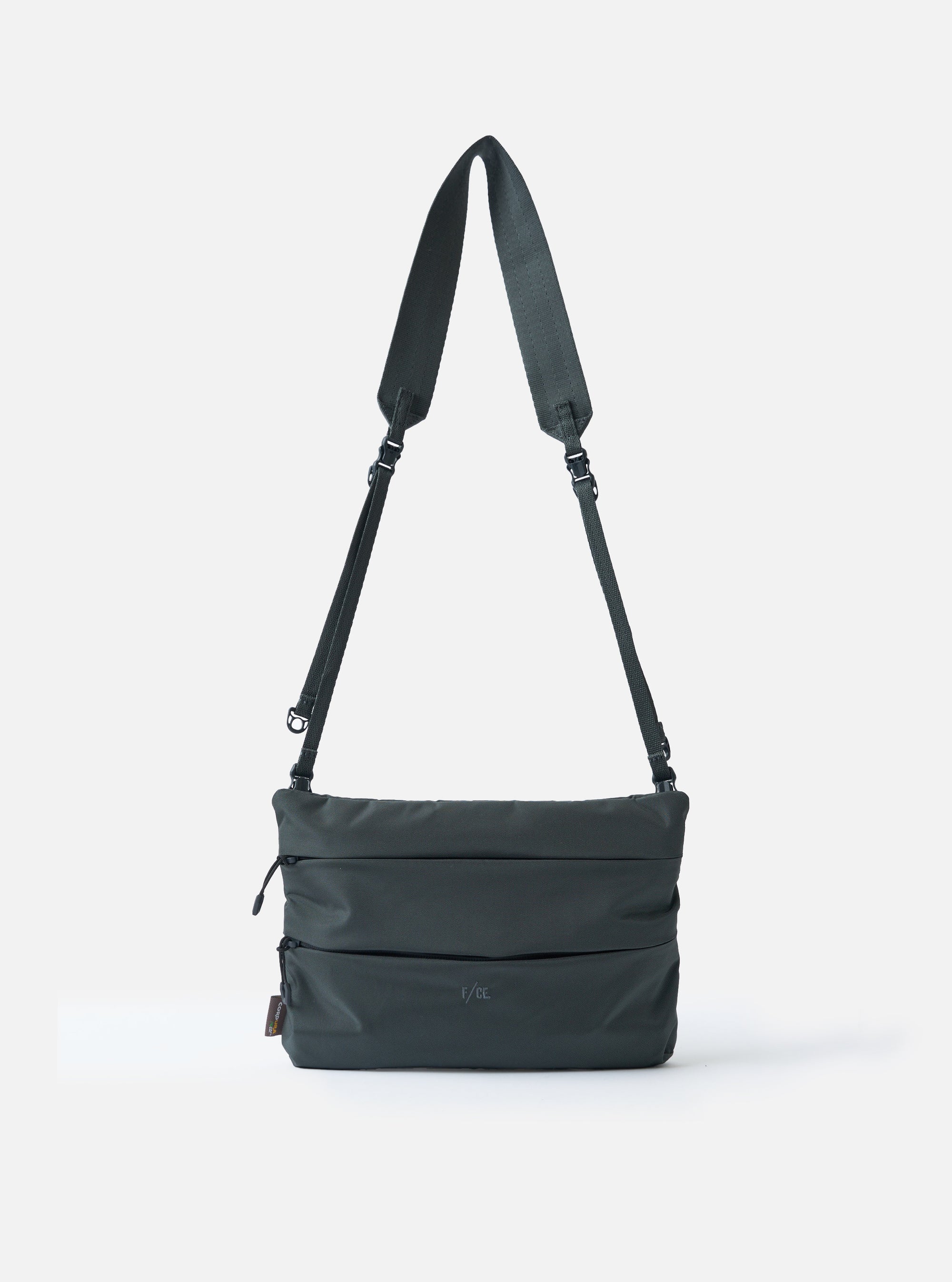 The F/CE.® Grey 420 re/cor Sacoche bag on a white background. The grey bag has a long adjustable strap. The bag is made of a durable material with a subtle texture.