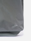 The F/CE.® Foliage Green Recycled Nylon 420 re/cor Courier Shoulder Bag is shown from a side-profile angle as a flat lay against a white background. The image highlights the depth and structured form of the messenger-style bag, featuring a foliage green technical fabric and a wide, adjustable black webbing shoulder strap.