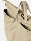 Close-up of the F/CE.® Sage Green Recycled Twill 3-Way Helmet Bag. The sage green bag, made of twill, features pockets with silver snap closures. Shot against a white backdrop.