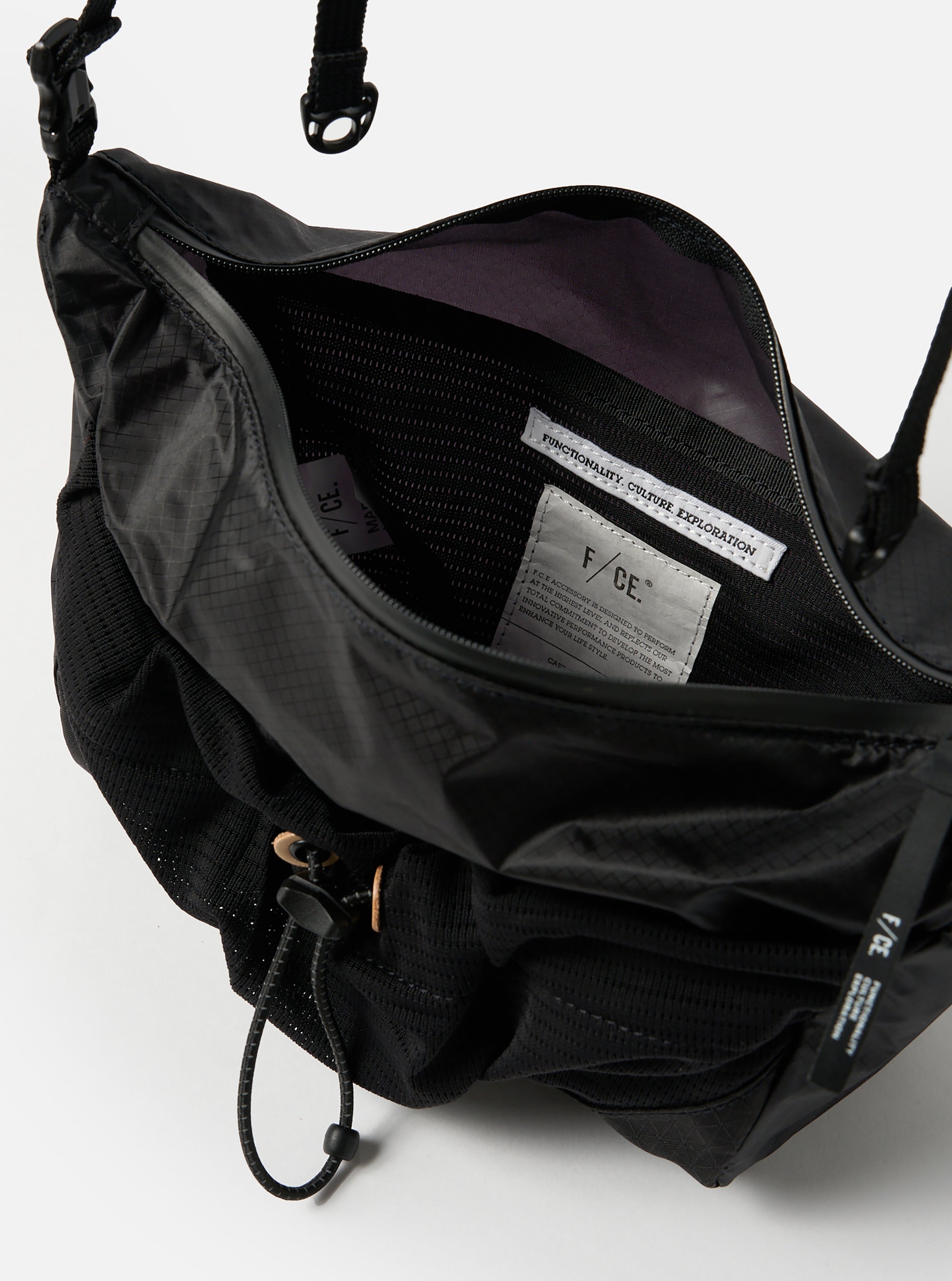Close-up of the F/CE.® Black Nylon Cordura Sil Sacoche, showcasing its open top, black nylon material, mesh details, and adjustable strap against a plain white background.