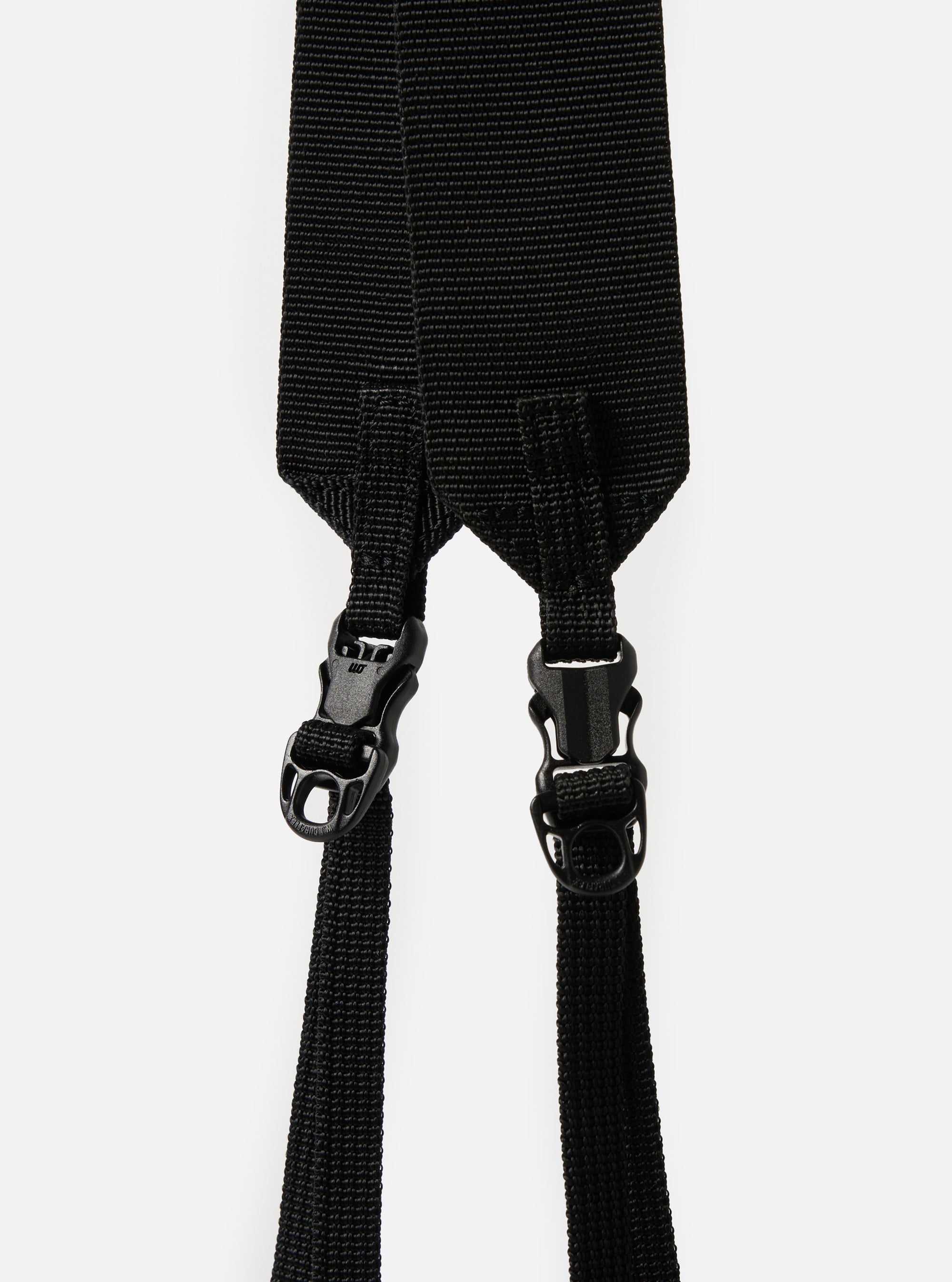 Close-up of the black nylon straps and plastic buckles of the F/CE.® Black Nylon Cordura Sil Sacoche against a white backdrop. The straps are textured and the buckles are matte.