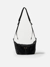 The F/CE.® Black Nylon Cordura Sil Sacoche bag hangs against a white backdrop. The black nylon bag features a drawstring closure and adjustable straps.