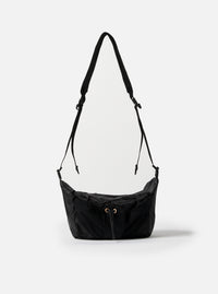 The F/CE.® Black Nylon Cordura Sil Sacoche bag hangs against a white backdrop. The black nylon bag features a drawstring closure and adjustable straps.