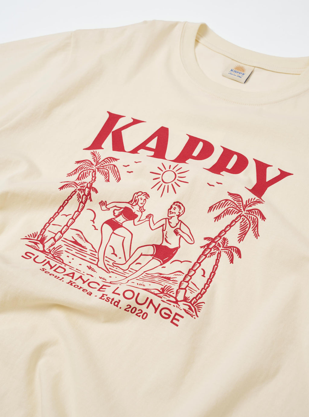 The Kappy Cream Sundance Lounge Half Tee is shown from a rear angle as a flat lay against a plain white background. The image highlights the oversized, boxy fit and the clean, wide-cut sleeves of the cream-colored cotton garment.
