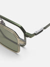 Close-up of A. SOCIETY x Universal Works Olive/Green Kowloon Eyewear on a white surface. Features olive green frames and silver accents. Stylish and modern eyewear.