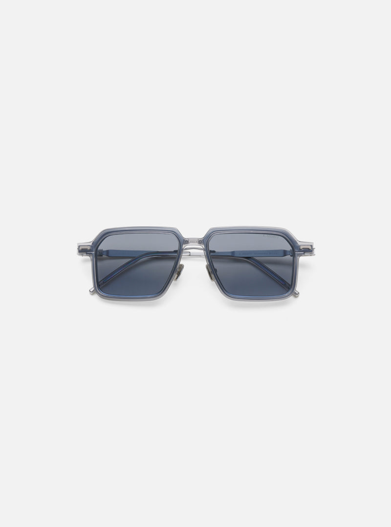 A. SOCIETY x Universal Works Silver/Grey Kowloon Eyewear on a white background. These square framed glasses have silver metal details and grey tinted lenses.