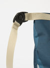 Close-up of the master-piece x Universal Works Blue Camo Recycled Tech Canvas Large Tote Bag showing the blue camo tech canvas, beige strap and black buckle on a white background.