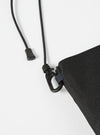 Close-up of the master-piece x Universal Works Black Recycled Tech Canvas Sacoche showing the black tech canvas material, black rope strap, and metal hardware on a white background.
