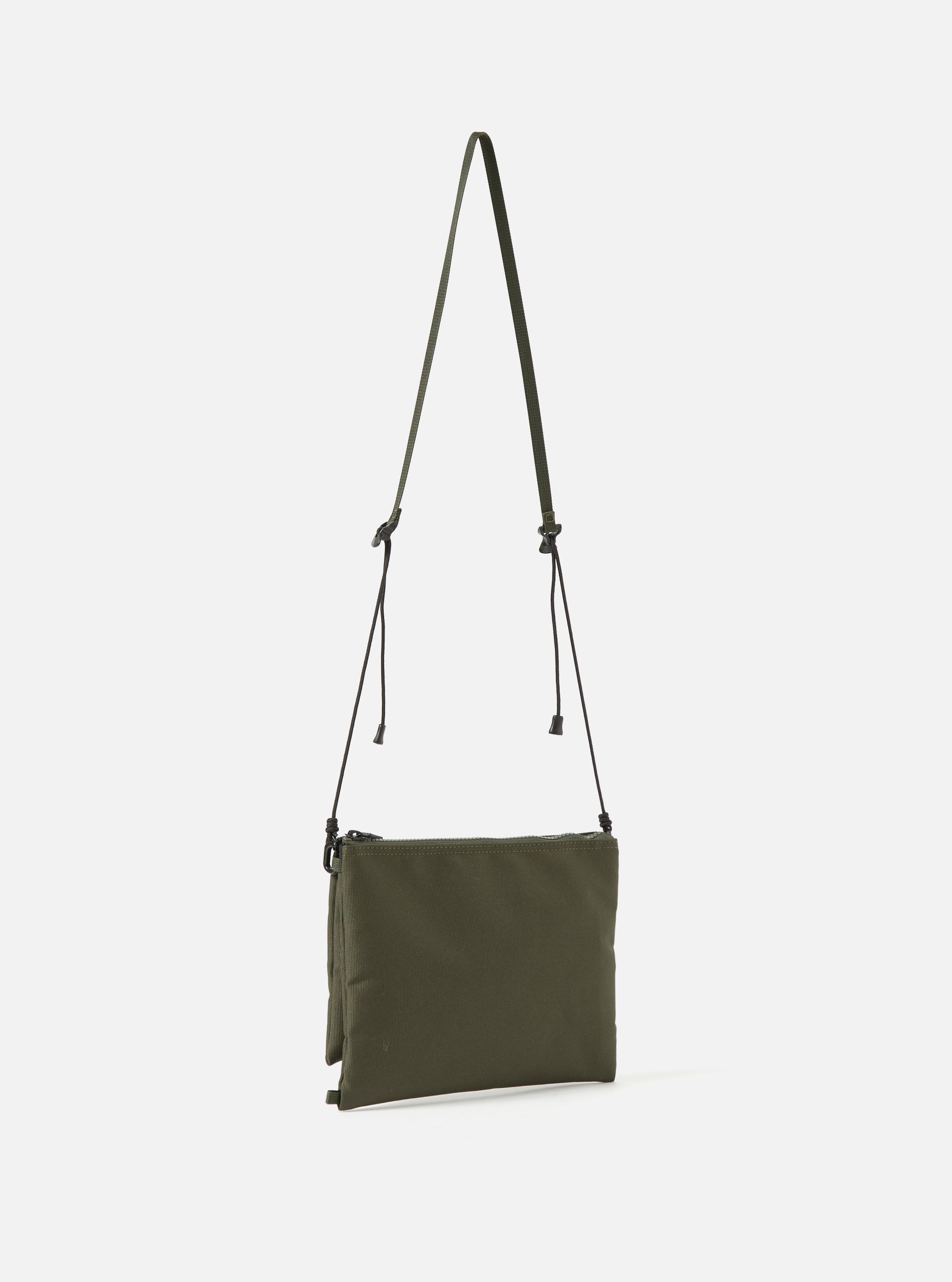 Olive master-piece x Universal Works Sacoche bag in recycled tech canvas. The crossbody bag features a slim profile and adjustable strap, presented on a clean white background.