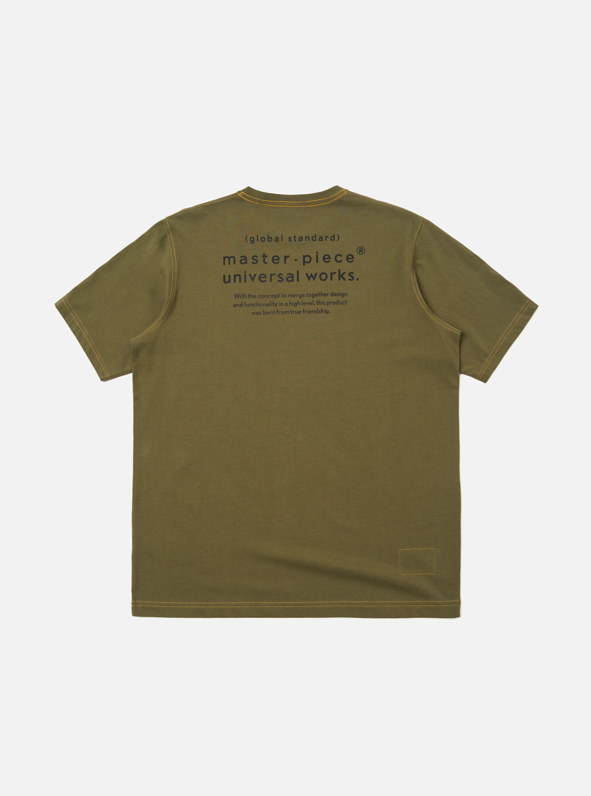 The master-piece x Universal Works Olive Single Jersey Print Tee is shown from the back as a flat lay against a white background. The image highlights the large graphic print on the upper back, featuring a geometric mountain-like design and collaborative branding. The t-shirt has a classic crew neck and short sleeves.