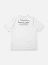 The master-piece x Universal Works White Single Jersey Print Tee is shown as a flat lay against a white background. The back of the white T-shirt is prominent, featuring a large graphic print and a horizontal storm flap across the upper back yoke.