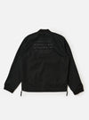 The master-piece x Universal Works Black Peached Poplin Newark Jacket is shown from the back as a flat lay against a plain white background. The image highlights the smooth texture of the black peached poplin fabric, the ribbed collar, and the ribbed hem. A small collaborative brand patch is visible on the upper back.