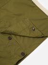 The master-piece x Universal Works Olive Recycled Poly Tech Tech Overshirt is shown from the back as a flat lay against a plain white background. The image highlights the back yoke with a central box pleat and the smooth, olive green recycled polytech fabric.