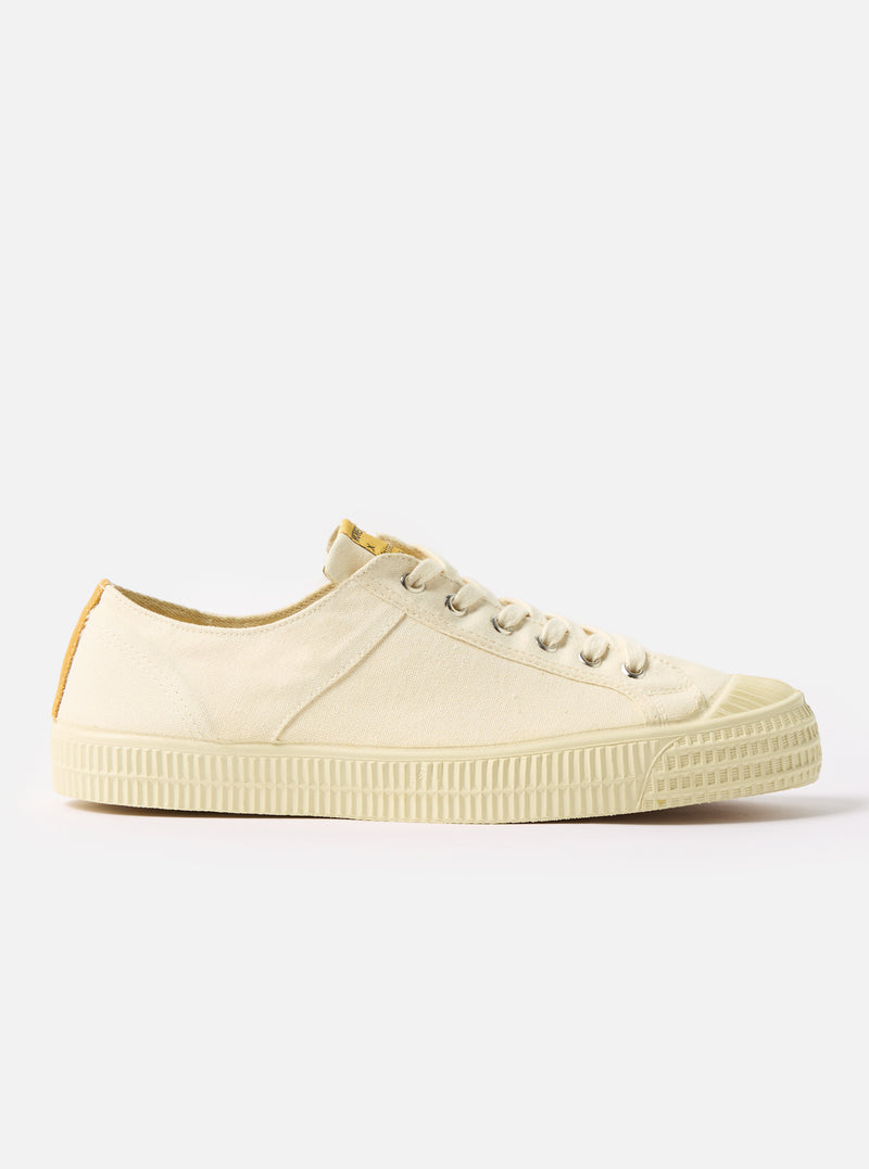 Side view of the Novesta for Universal Works Ecru Canvas Star Master shoe on a white background. The shoe is made of ecru canvas with a rubber sole.