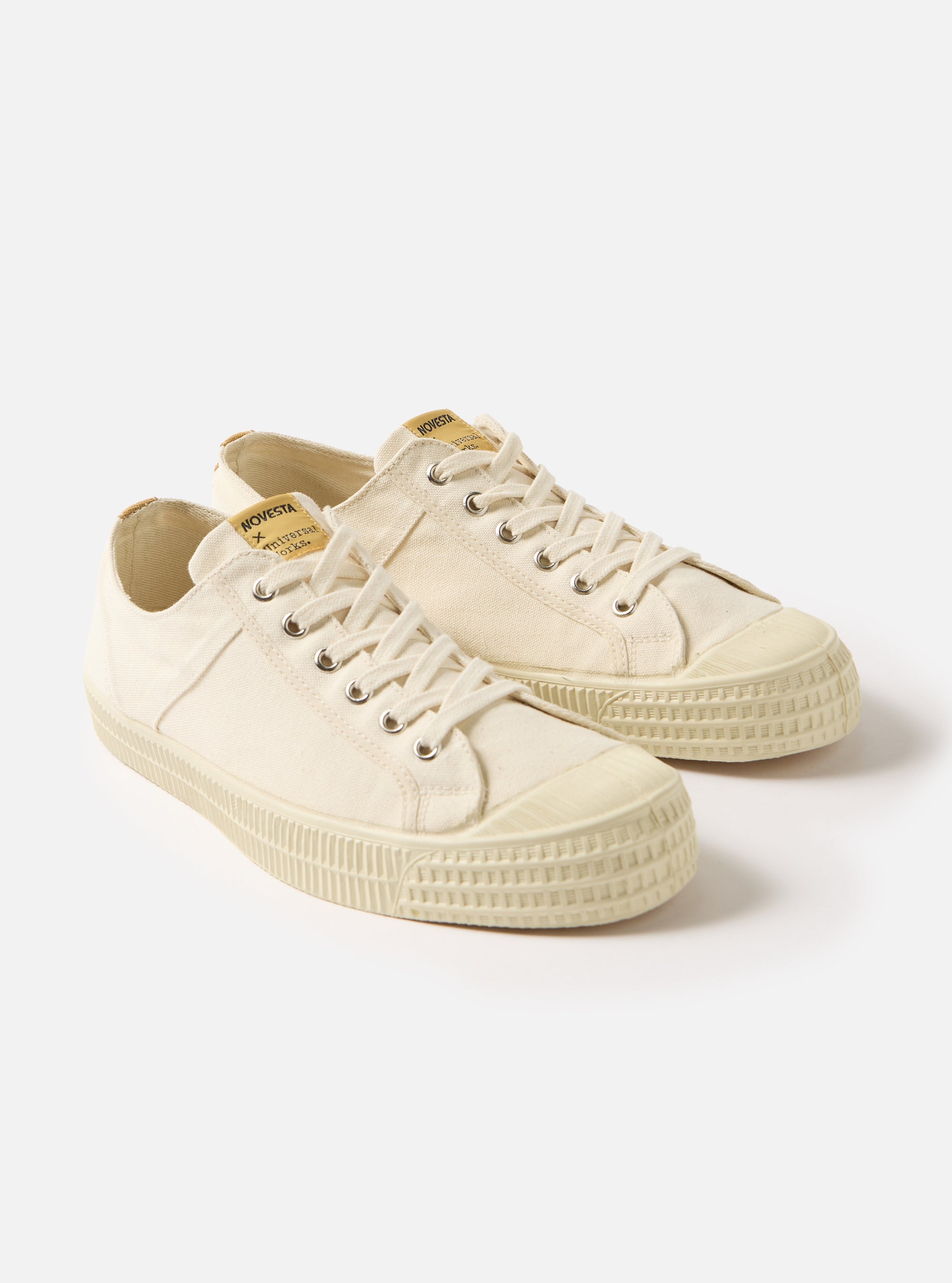 The Novesta for Universal Works Ecru Canvas Star Master shoes on a white background. The shoes are ecru canvas with white laces and a rubber sole.
