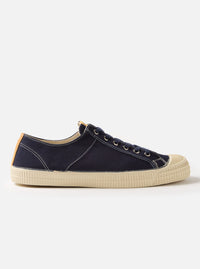 Side view of the Novesta for Universal Works Navy Canvas Star Master shoe on a white background. The shoe is navy canvas with a cream rubber sole.