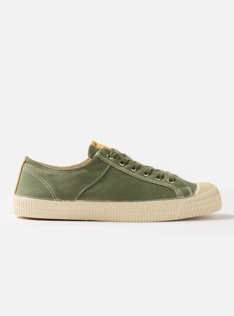 Side view of a Novesta for Universal Works Olive Canvas Star Master shoe on a white background. The shoe is olive green with a cream sole and laces.