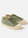 Studio shot of Novesta for Universal Works Olive Canvas Star Master sneakers. Olive canvas upper, off-white rubber sole. Simple white background.