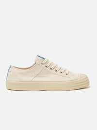 The Novesta for Universal Works Ecru/Pale Blue Canvas Star Master is shown from a side profile against a white background. The sneaker features an ecru canvas upper with military-inspired pale blue contrast stitching and a signature gold canvas heel tape. The shoe has a prominent chunky ecru vulcanized rubber sole with a textured shell toe and silver metal eyelets for the laces.