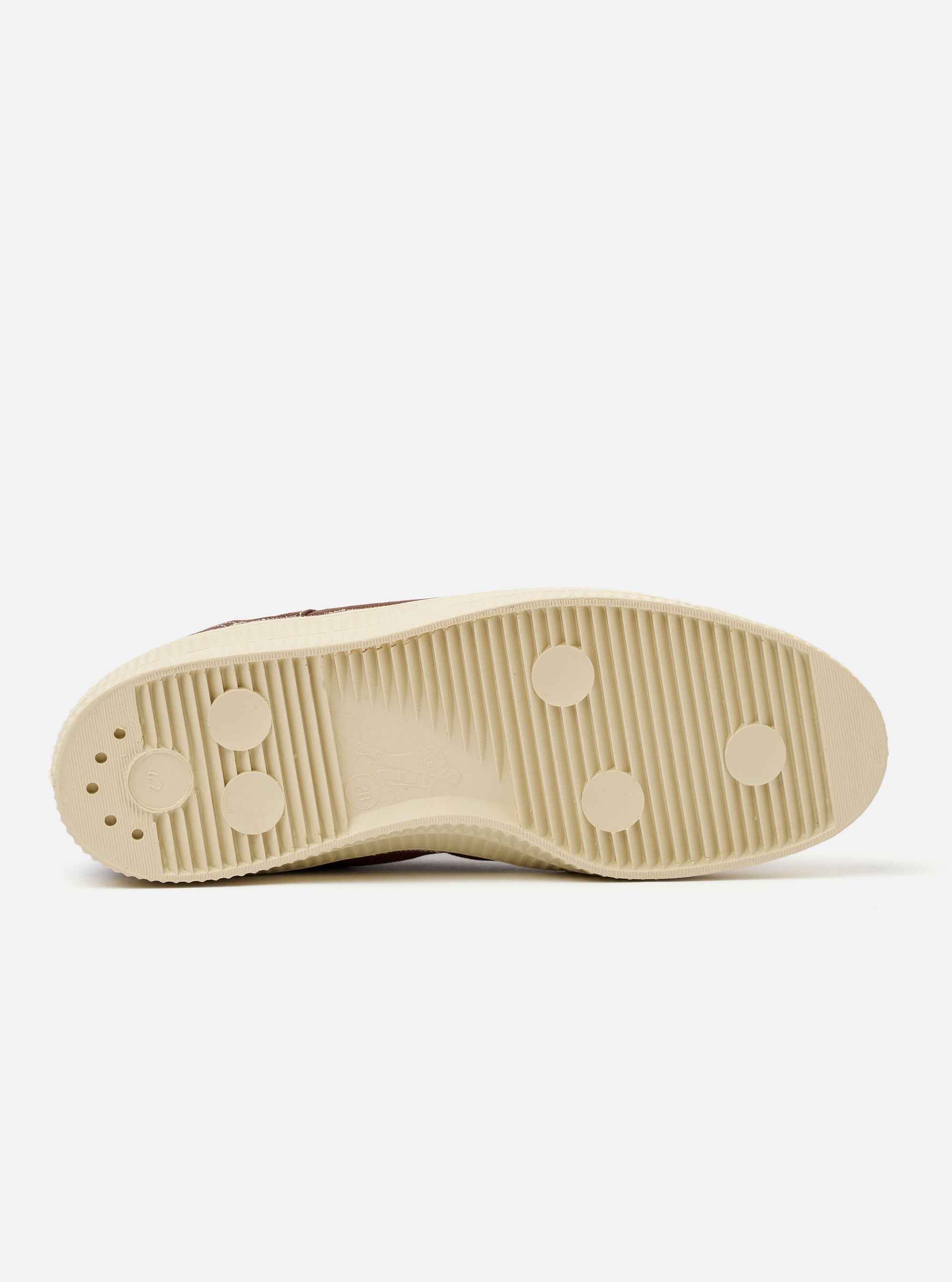 The Novesta for Universal Works Brown/Pale Blue Canvas Star Master is shown in a side-profile view against a white background. The sneaker features a brown cotton canvas upper with contrast stitching and metallic eyelets. A prominent chunky ecru vulcanized rubber sole with a textured tire-like pattern wraps around the base and toe cap. A small pale blue pull tab is visible on the heel.