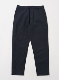 The Navy Linen Slub Weave Military Chino laid on a white surface. The pants are a dark navy color and made of a textured linen material. 