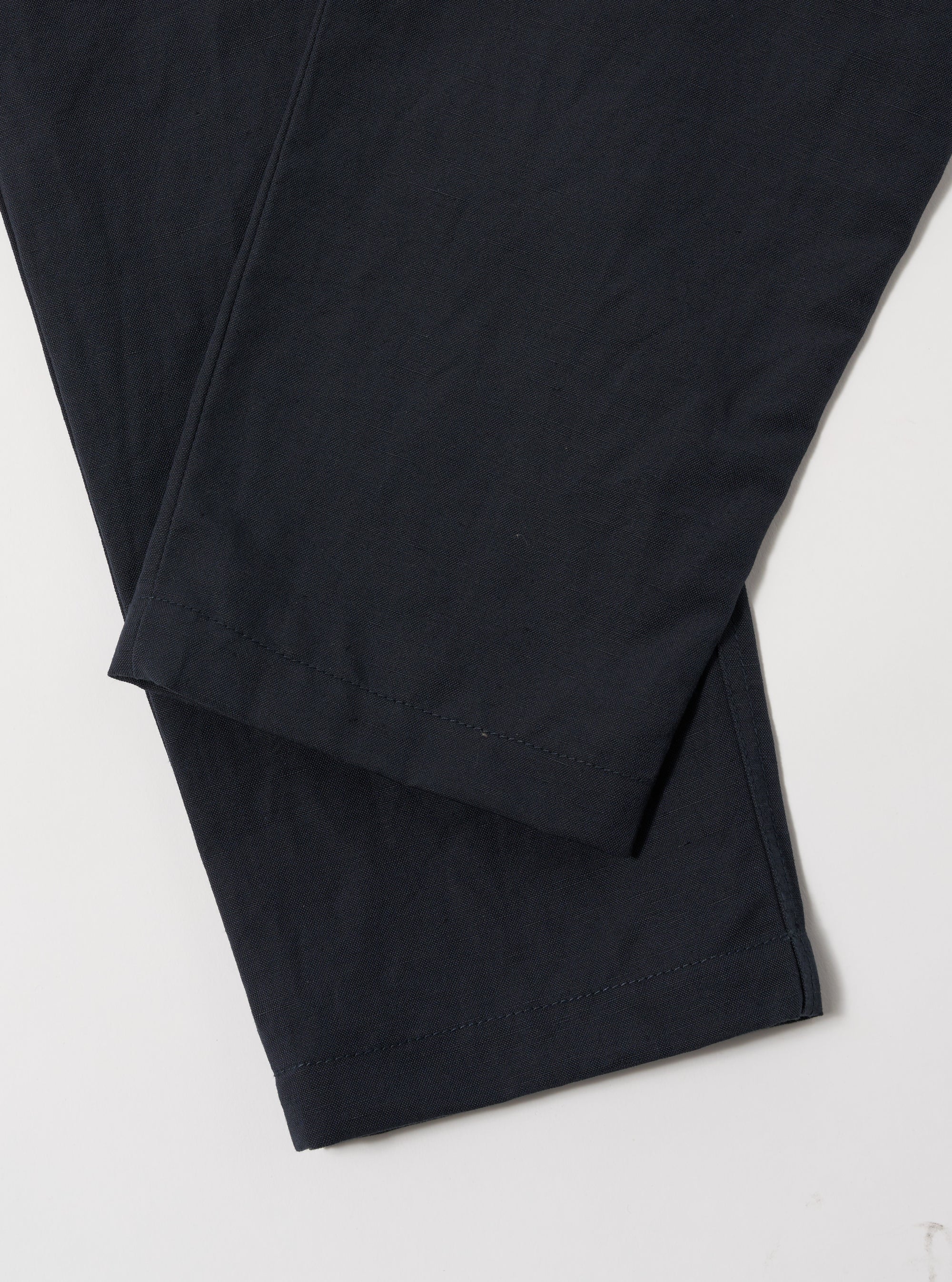 Close-up of the Navy Linen Slub Weave Military Chino on a white surface. The navy color and linen texture are visible.
