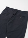 Close-up of the back of Navy Linen Slub Weave Military Chino pants on a white surface. The linen texture and button details are visible.