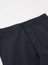 Close-up of the Navy Linen Slub Weave Military Chino on a white surface. The navy linen fabric and button are clearly visible.