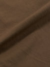 Close-up of the Khaki Linen Slub Weave Oxford Pant fabric. The material is a textured khaki linen, draped on a plain surface to show the weave.