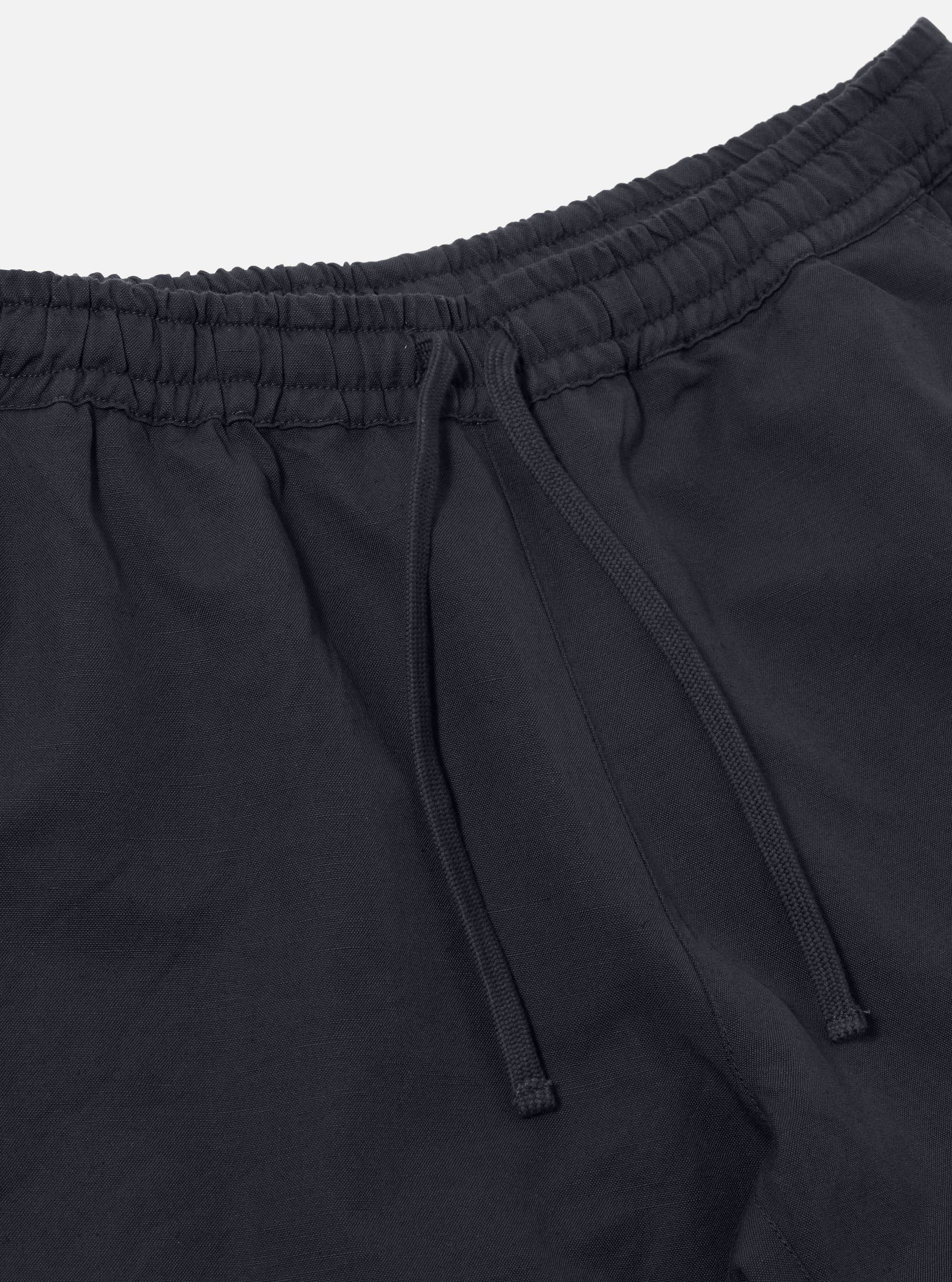 Close-up of the Navy Linen Slub Weave Simple Short, showcasing the elastic waistband with drawstring. The navy linen fabric is visible against a white backdrop.