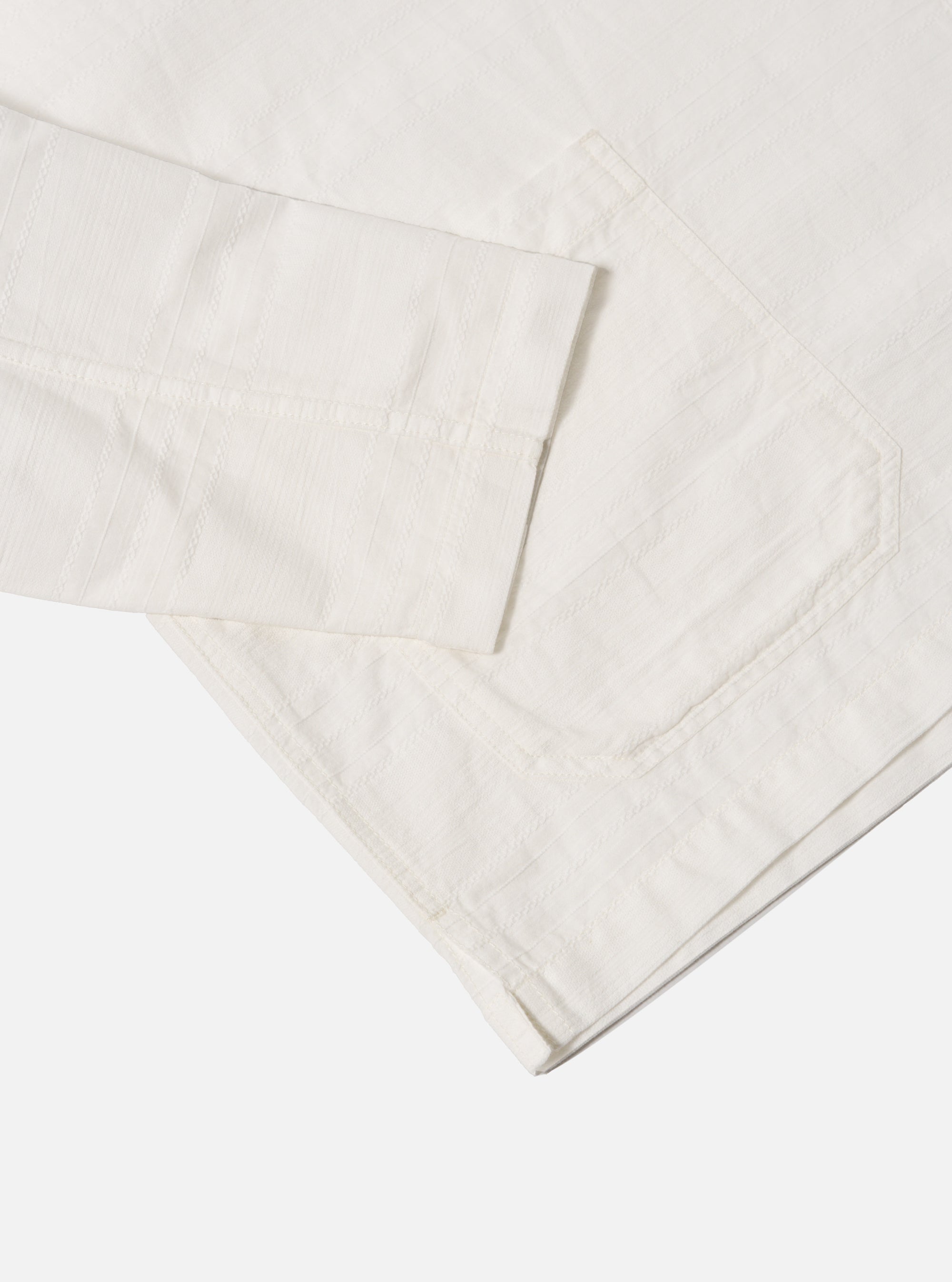 Close-up of the ecru Deffe Self Stripe Smock Overshirt on a white background. The light fabric shows subtle stripes and a relaxed fit.